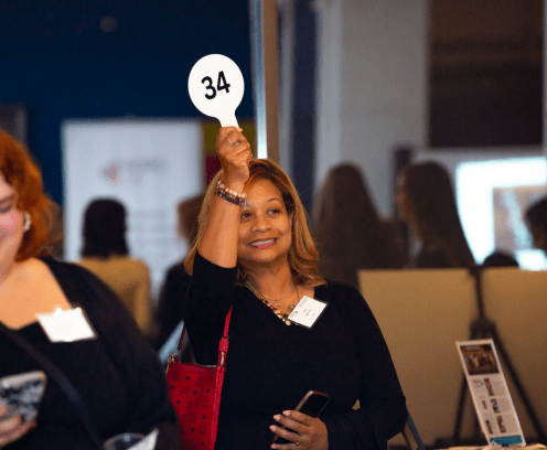 woman-holding-up-auction-paddle