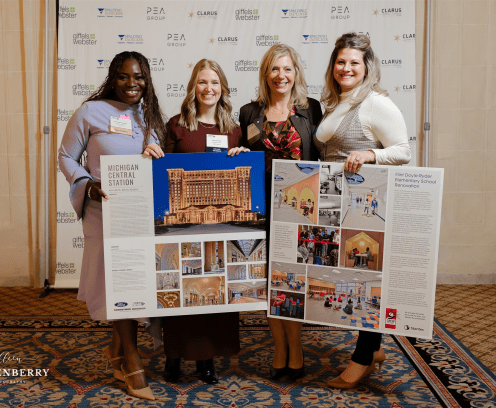 four women holding signs at impact awards luncheon