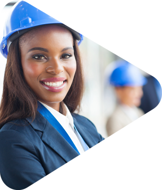 businesswoman smiling in hard hat with others out of focus in the background