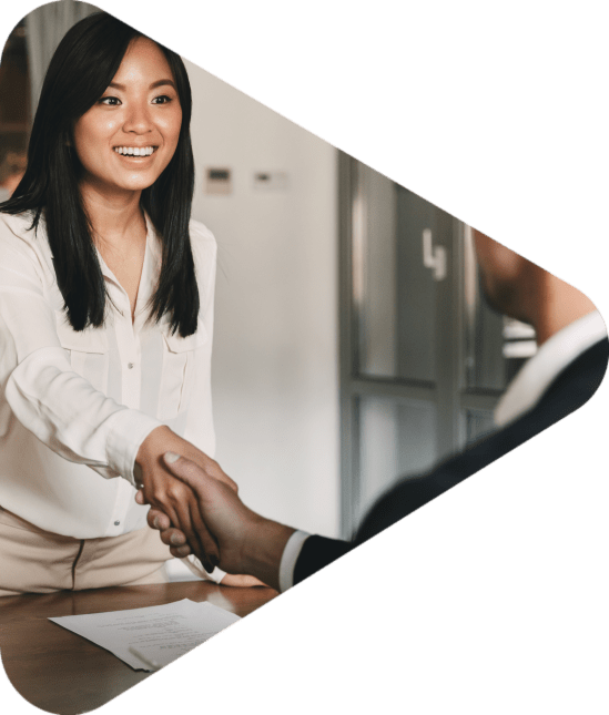 Business, career and placement concept - image from back of two employers sitting in office and shaking hand of young asian woman after successful negotiations or interview