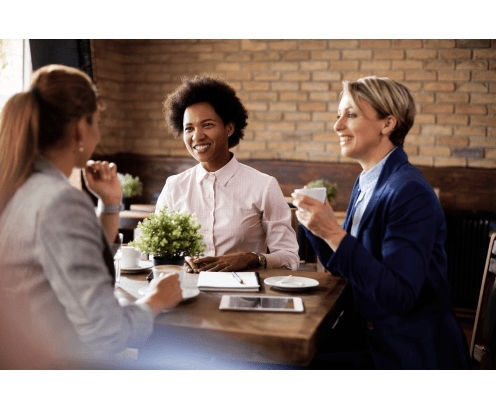 Three women at a table, networking