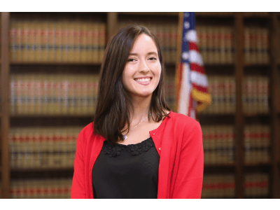 Woman smiling in library in front of American flag