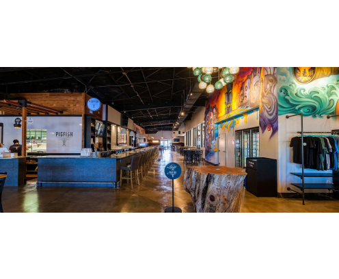 Restaurant interior with take out counter, looking down a long bar across from a wall with a colorful, nautical themed mural.