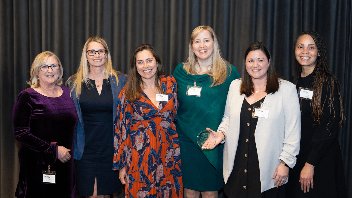 6 people with one woman holding an award