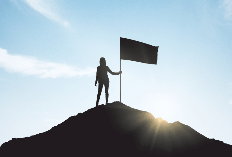 woman with flag silhouette at summit