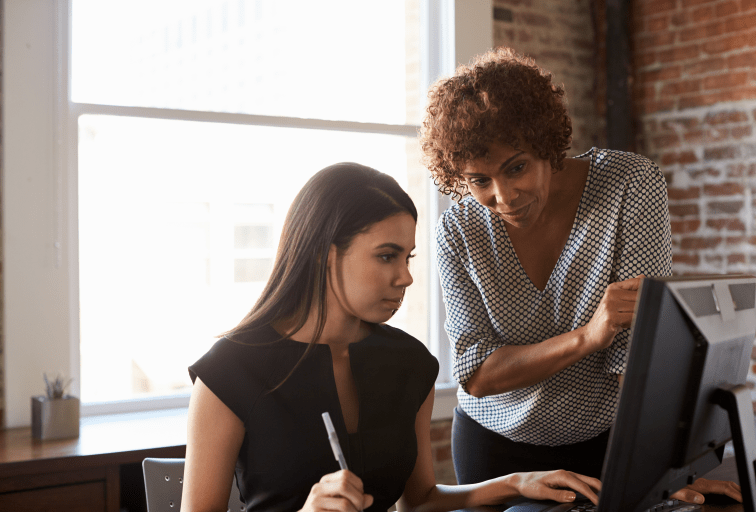 Two Businesswomen Working On Computer In Office mentor concept