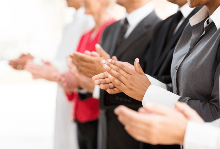 group of businesspeople clapping hands during meeting presentation