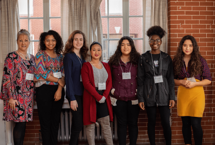 Group photo of students and a businesswoman at a CREW career event