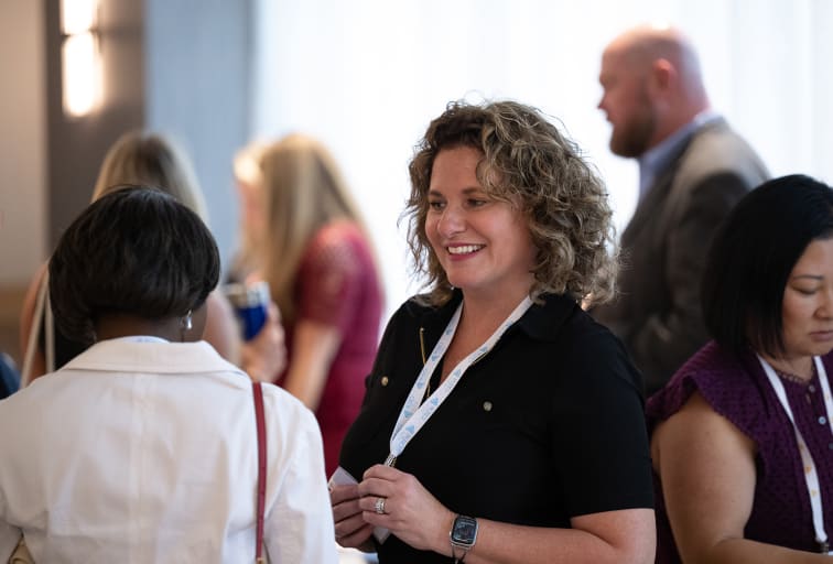woman smiling conversing at a networking event