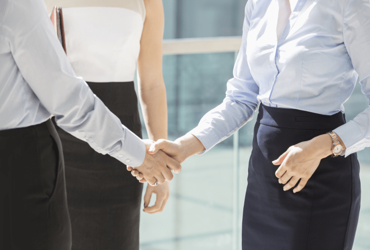 Midsection of businesswomen shaking hands in office