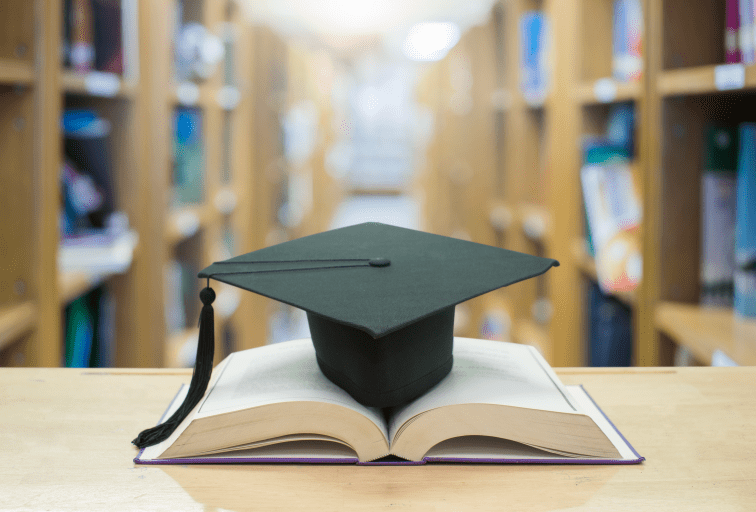 graduation cap over open Books on Library room,Education concept