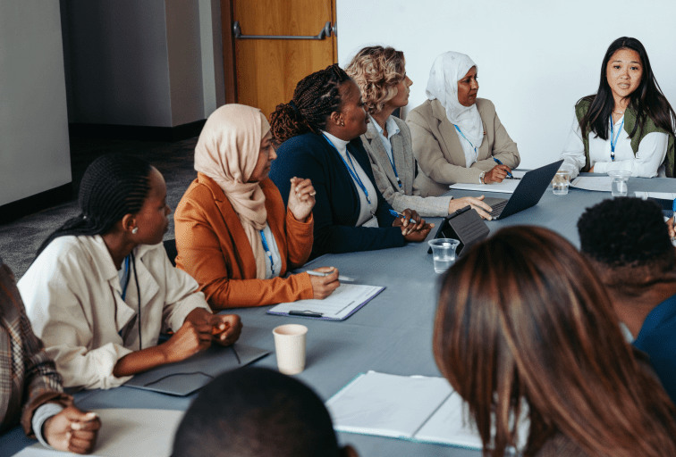 A multiethnic team engaged in a collaborative meeting workshop, focusing on discussion and teamwork. Diverse professionals working together around a conference table.