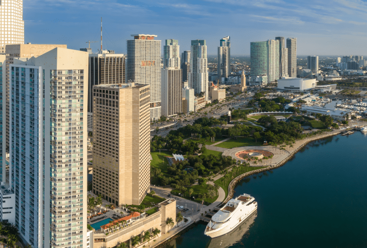 Downtown city skyline and calm ocean waterfront and Bayfront Park of Miami at sunrise, Florida, United States.