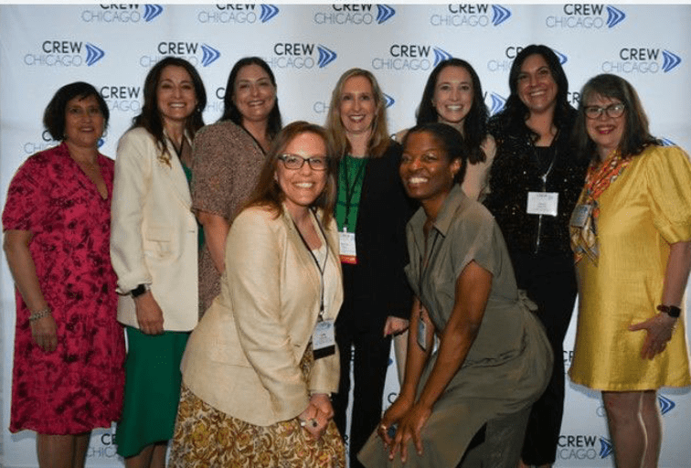 ladies from CREW Chicago Awards dinner standing in front of CREW Chicago banner