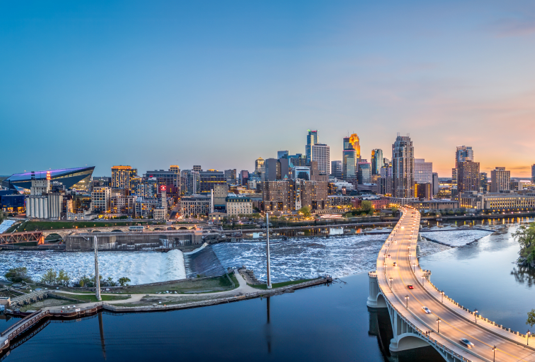 Minneapolis, Minnesota, USA downtown city skyline over the river at dusk.