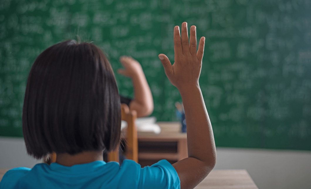kid raising his hand in classroom