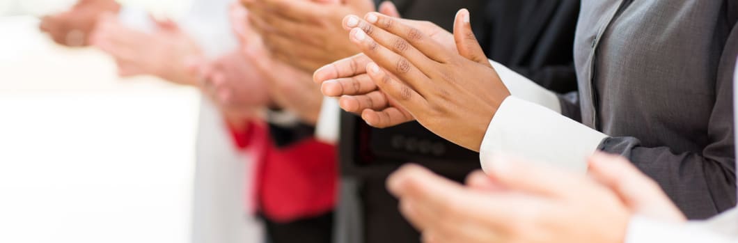 group of businesspeople clapping hands during meeting presentation