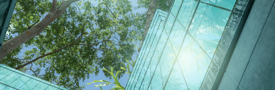 Eco-friendly building in the modern city. Sustainable glass office building with trees for reducing heat and carbon dioxide. Office building with green environment. Corporate building reduce CO2.