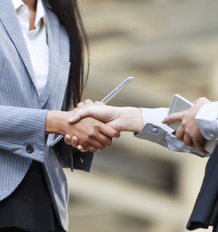 business women shaking hands with iphone and tablets in their hands