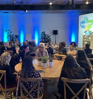 People sitting at tables at MIPIM 2023