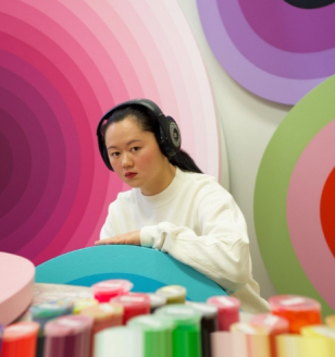 Linling Lu in studio displaying her art.