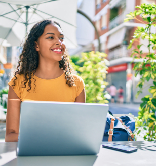 Young african american student girl using laptop sitting on the table at terrace.; Shutterstock ID 1928460668; purchase_order: -; job: -; client: -; other: -