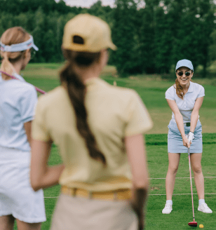 lady putting on golf course with two other ladies watching