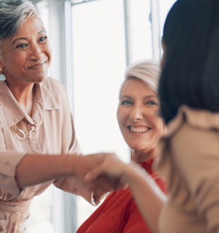 Meeting, handshake and collaboration with a business woman in partnership with her team in the boardroom. Welcome, teamwork and diversity with a female leader and employee group working in the office.