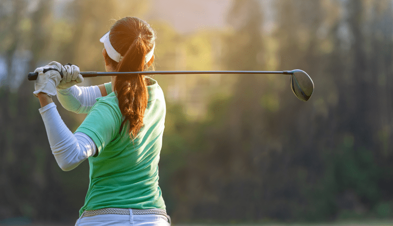 Sport Healthy. Asian sporty woman golf player doing golf swing tee off on the green sunset evening time, she presumably does exercise. Healthy and Lifestyle Concept.