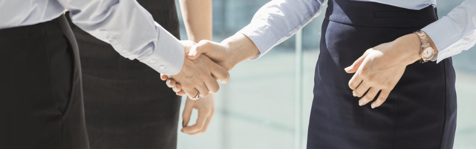 Midsection of businesswomen shaking hands in office