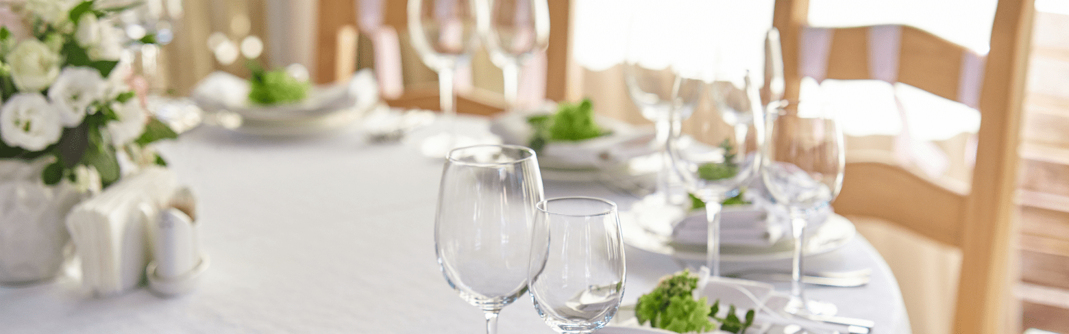 beautifully decorated festive table with plates and glasses and a bouquet of flowers in a restaurant