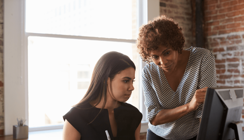 Two Businesswomen Working On Computer In Office mentor concept