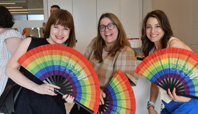 three-ladies-holding-rainbow-colored-fans
