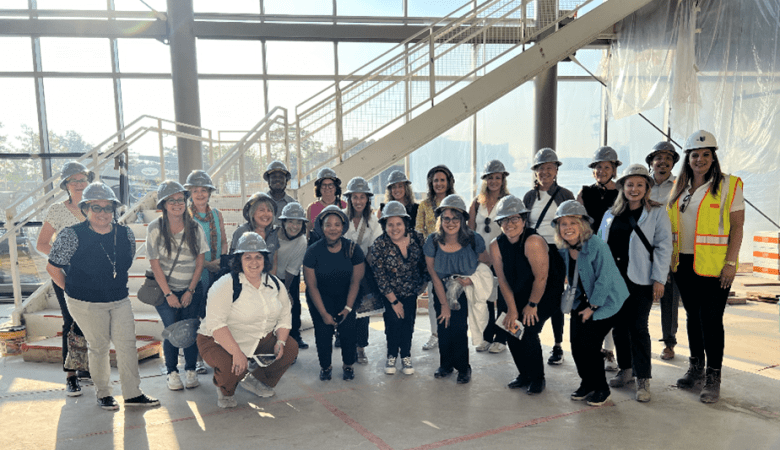 Several ladies wearing hard hats standing in a new building