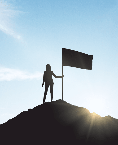woman with flag silhouette at summit