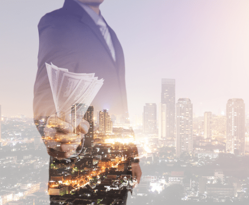 businessman holding dollar bills shadow image on top of cityscape image