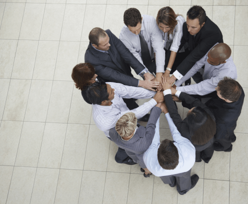 Top view of successful businesspeople putting their hands together