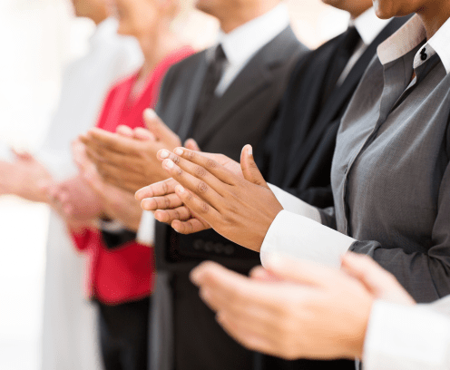 group of businesspeople clapping hands during meeting presentation