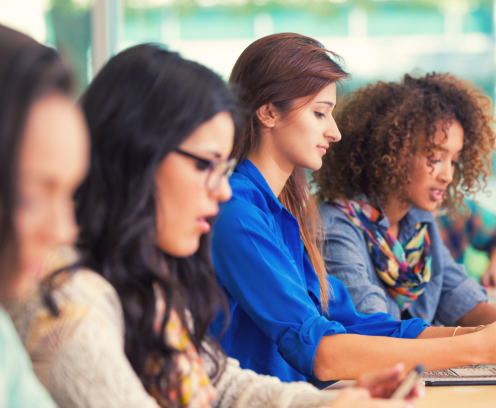 High school or college girls using smart phones in classroom