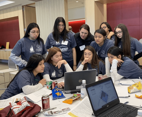 students surrounding a laptop