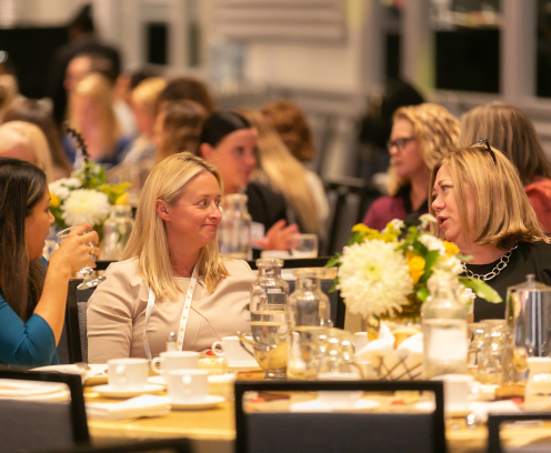 Three women networking at lunch table.