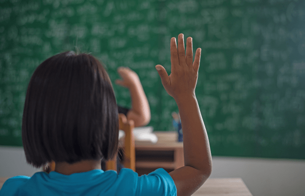 kid raising his hand in classroom