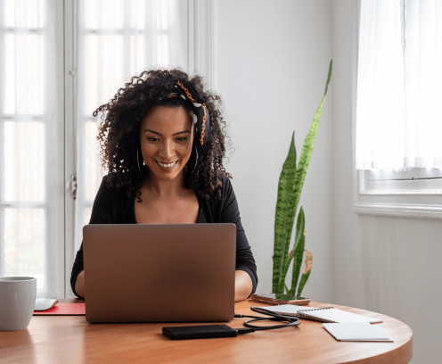 Shot of young latin woman working at home with laptop and documents