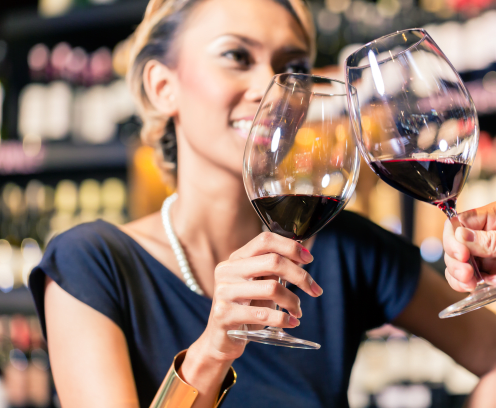 Close up of Asian couple clinking glasses in wine shop