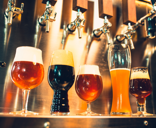 The beer taps in a pub. nobody. Selective focus. Alcohol concept. Vintage style. Beer craft. Bar table. Steel taps. Shiny taps. Glass of beer