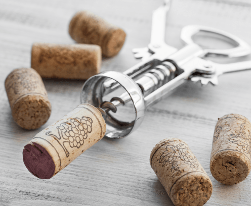 Corkscrew and wine corks on wooden background