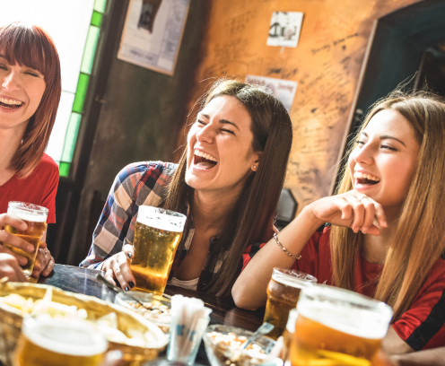 Happy girlfriends women group drinking beer at brewery bar restaurant - Friendship concept with young female friends enjoying time and having genuine fun at cool vintage pub - Focus on left girl