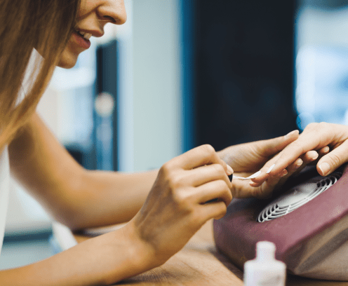 Close-up portrait of woman doing nail polish in beauty salon