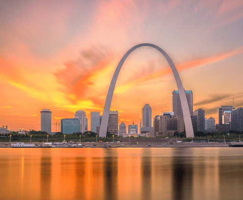 St. Louis, Missouri, USA downtown cityscape with the arch and courthouse at dusk.