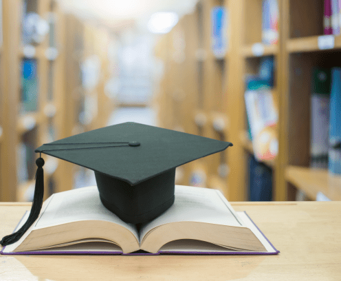 graduation cap over open Books on Library room,Education concept